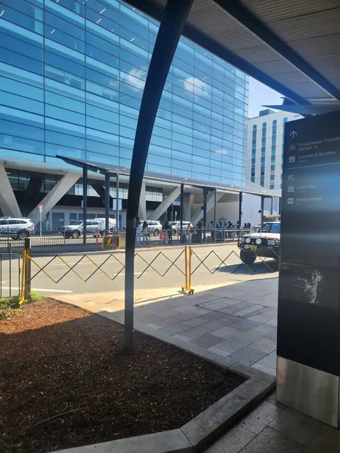 Glass walls and signage at the airport terminal arrival area.