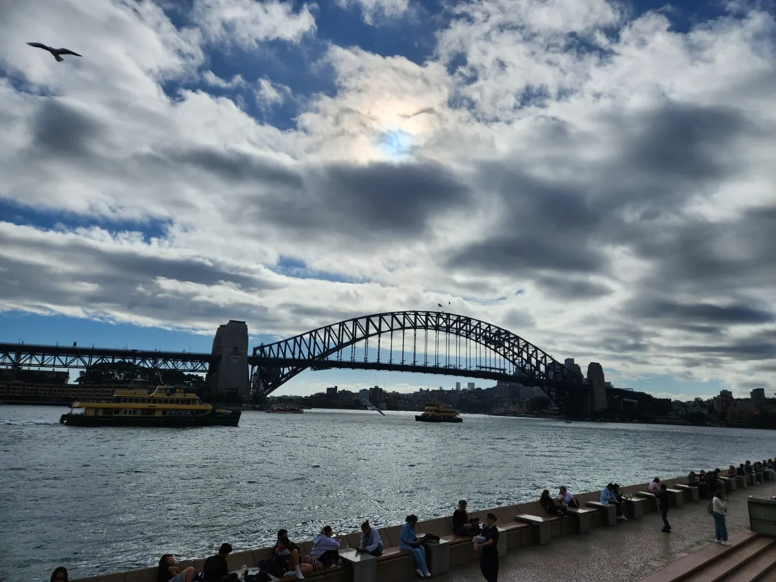 Ferries in the harbor with the Sydney Harbour Bridge in the background.
