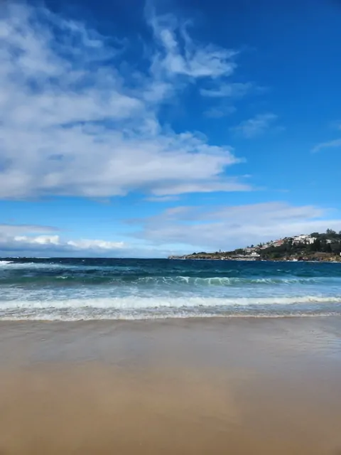 Emerald waves and golden sands of Bondi Beach seen from the hills.