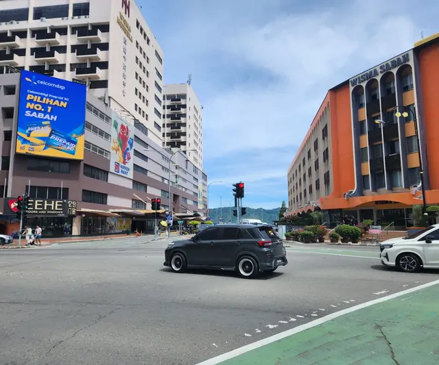 The orange Wisma Sabah building and a city intersection in the downtown area.
