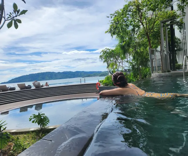 Looking out at the ocean and mountains from a resort infinity pool.