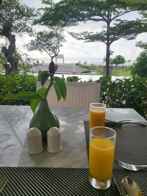 Fresh orange juice and flowers for breakfast with an ocean view.