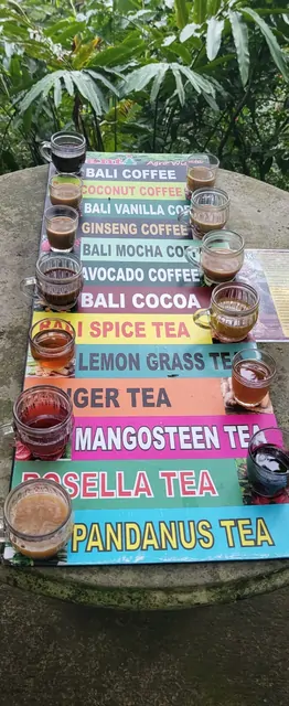 Samples of local Bali coffee and herb teas at a colorful cafe.