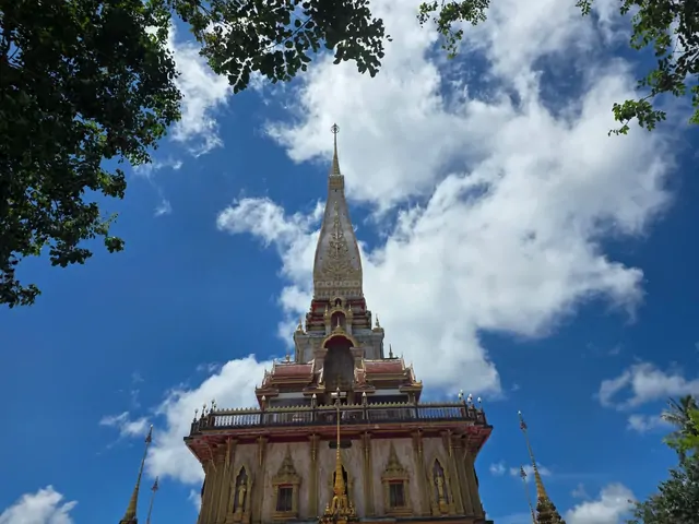The golden spire of Wat Chalong reaching toward the clouds.