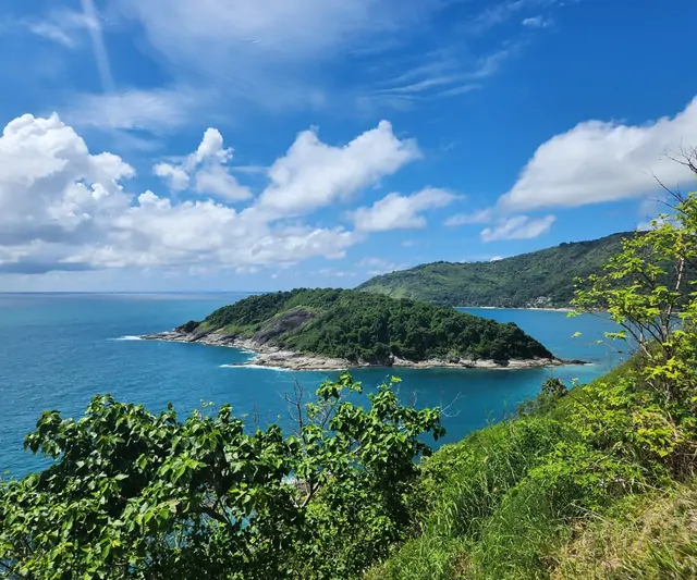 Emerald waters and a forested peninsula near Promthep Cape.