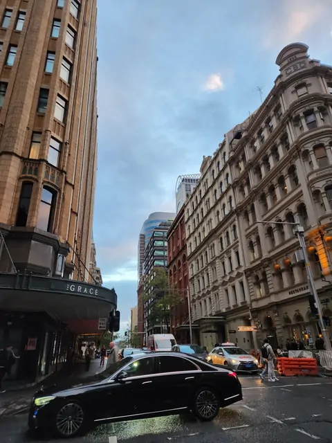Historic stone buildings at a CBD intersection under a twilight sky.