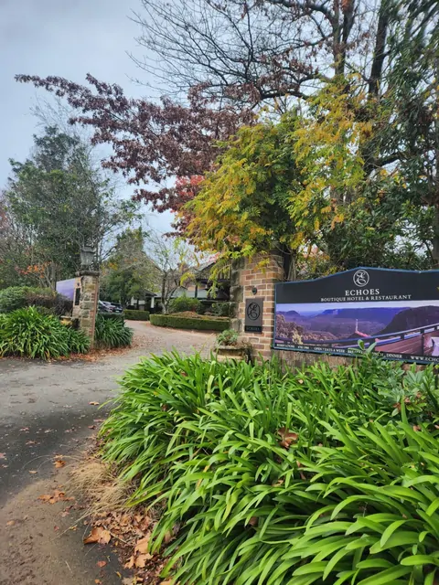 The brick entrance and autumn trees of the Echoes Boutique Hotel.