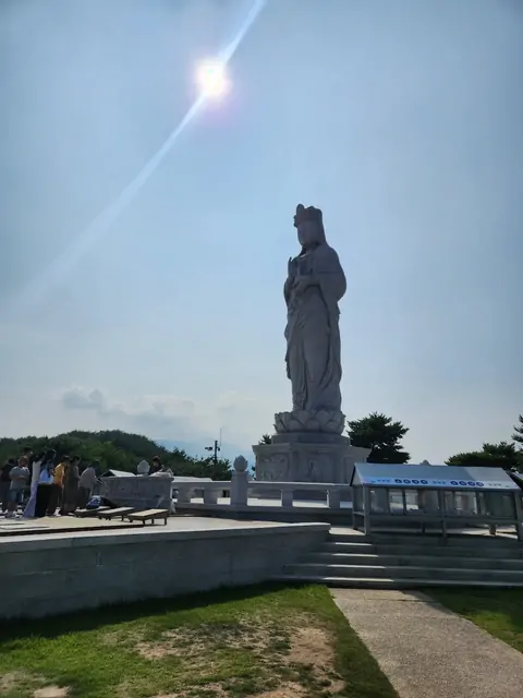 A large stone statue of Avalokitesvara at a temple.
