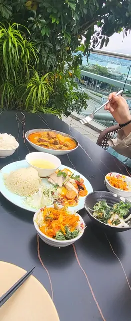 A hearty lunch of curry, rice, and salad at a scenic restaurant.
