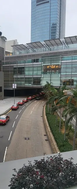 Red taxis lined up in front of the glass skyscrapers of the city center.