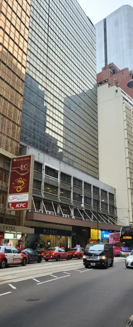 A busy street scene with high-rise buildings and a KFC sign.