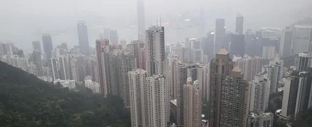 A high-angle view of the harbor and skyscrapers shrouded in fog.