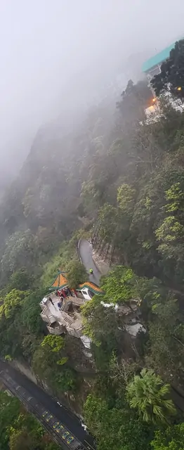 Traditional buildings and a winding road amidst the mountain mist.