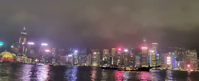 Bright city lights reflecting on the surface of Victoria Harbour.