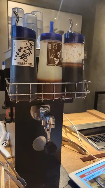 Condiment sets on a table inside a Japanese ramen shop.