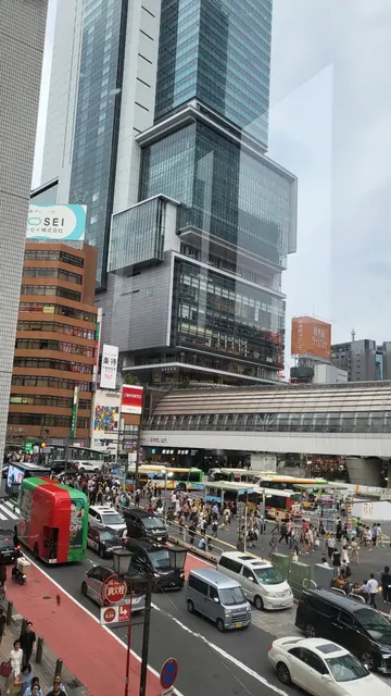 Crowded intersection with pedestrians and tall buildings in Shibuya.