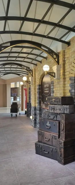 Vintage suitcases on a brick platform with arched ceilings at a retro station.