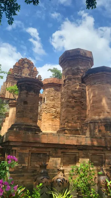 The red brick towers of the Po Nagar ruins under a blue sky.