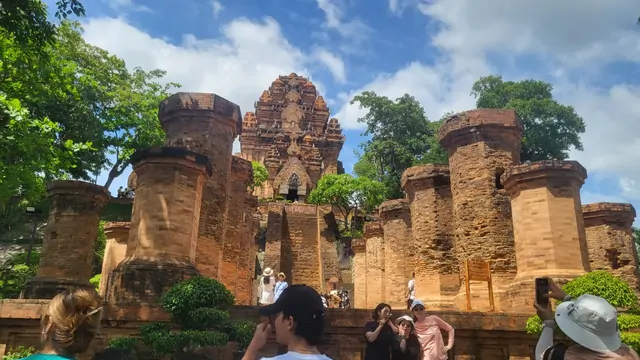 Tourists taking photos against the backdrop of the ancient red towers.