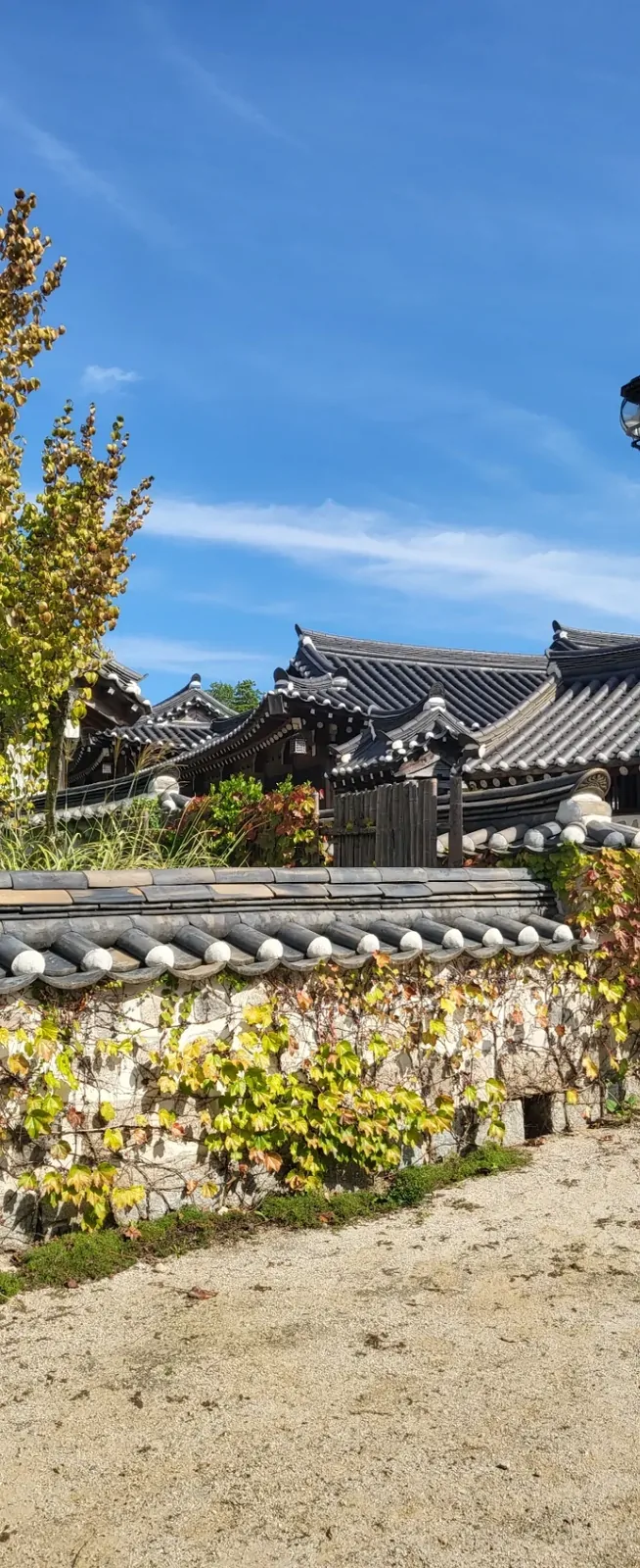 Autumn leaves framing the tiled roofs and stone walls of a traditional village.