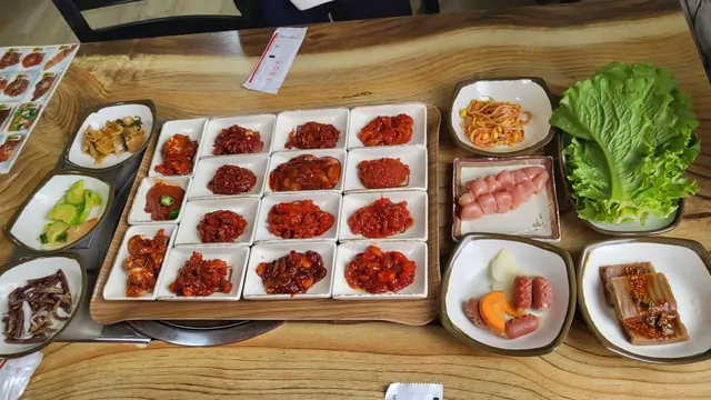 A full Korean barbecue spread with various side dishes and fresh vegetables.
