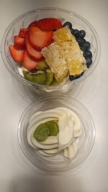 Fresh fruit yogurt bowls topped with honeycomb and berries.
