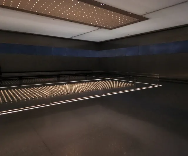 Symmetrical LED grid lighting in a modern exhibition space.