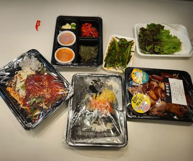 A variety of Korean delivery food including bibimbap and chicken.
