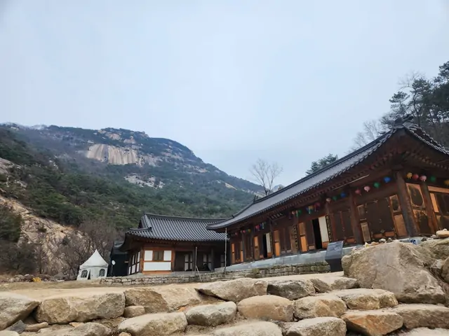 Traditional Korean temple set against steep granite cliffs.