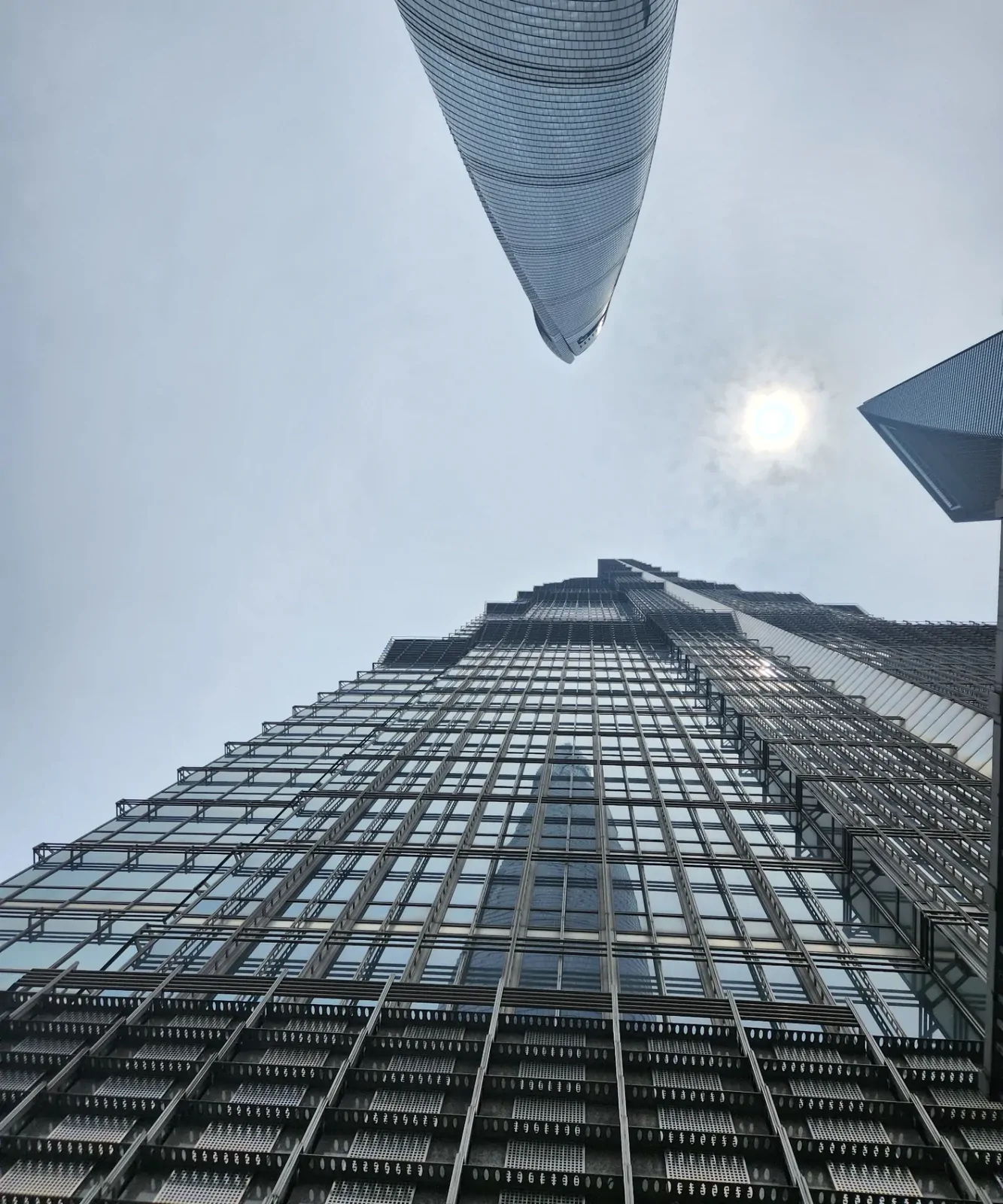 Looking up at the curved glass walls of the Shanghai Tower in Lujiazui.