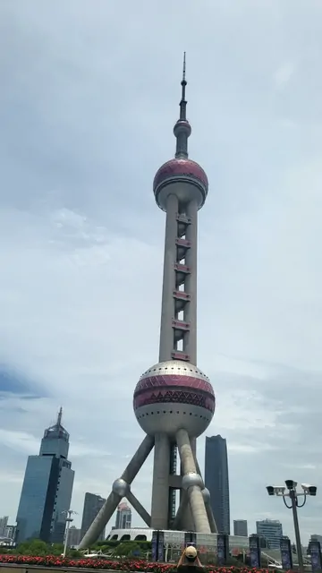 The Oriental Pearl Tower standing tall under a cloudy sky.
