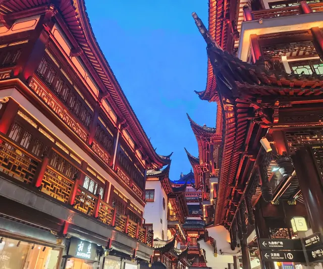 Red-lit traditional eaves viewed from a street near Yu Garden.