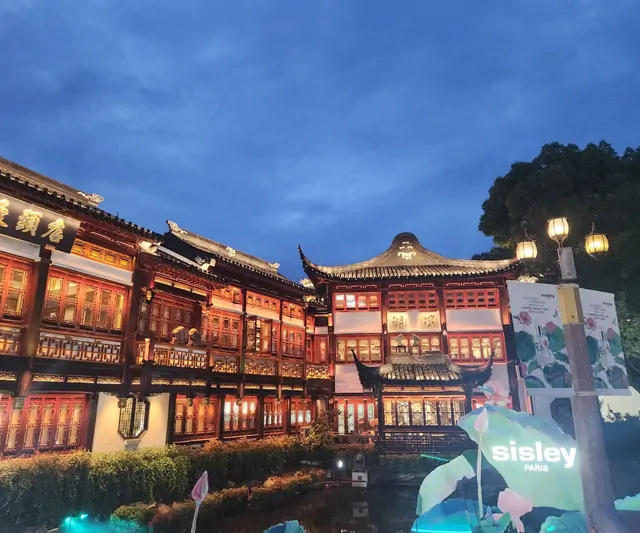 A brilliantly lit traditional wooden building glowing in red at night.