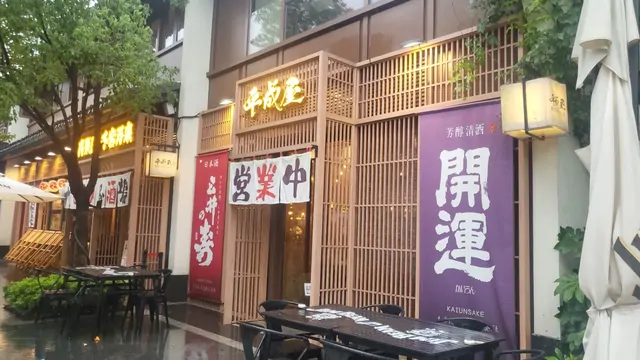 Rain-soaked izakaya street with traditional noren curtains.