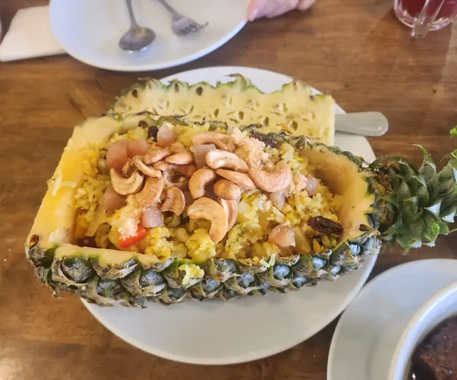 Thai pineapple fried rice served in a pineapple shell with cashews.